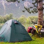 Bicicleta carregada ao lado de uma barraca de camping em uma cicloviagem